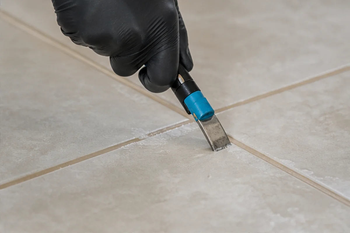 Close professional detail of tile & grout cleaning assessment in a St. John home